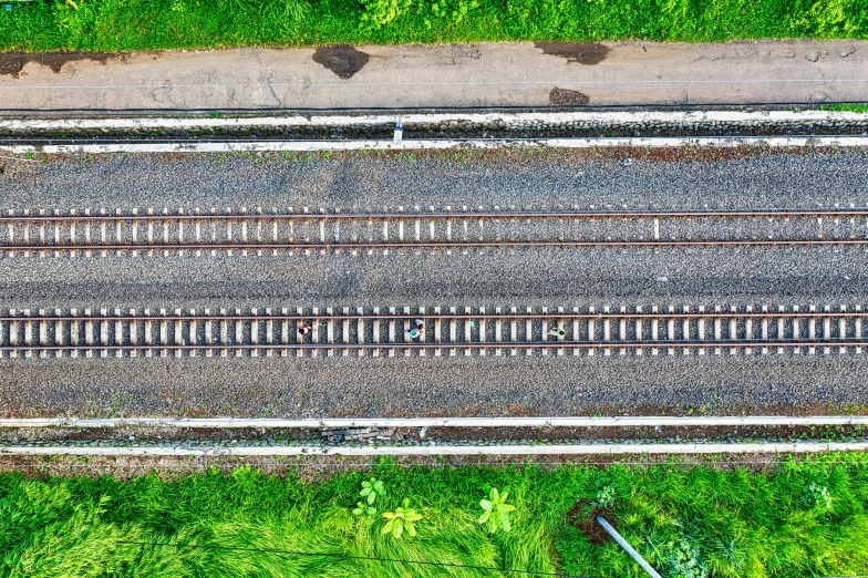 a train traveling down train tracks next to a lush green field, unsplash, square lines, satellite view, maintenance photo, thumbnail