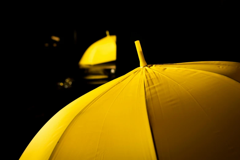 a close up of a yellow umbrella in the dark, mustard, reflection, colour photograph, commercial photograph