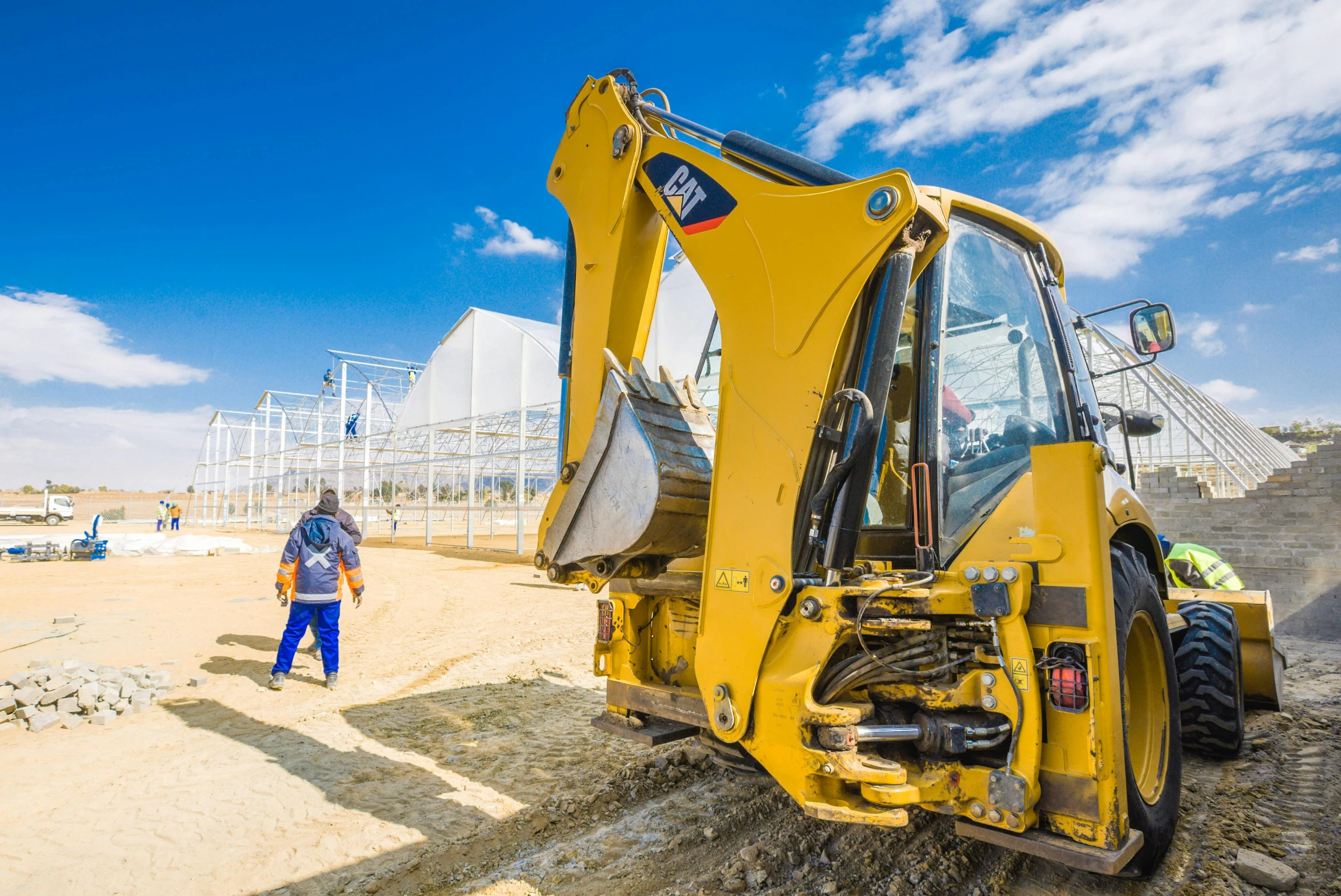 a man standing next to a bulldozer on top of a dirt field, by Julia Pishtar, unsplash, renaissance, greenhouse in the background, the caterpillar, venus project, high quality product image”