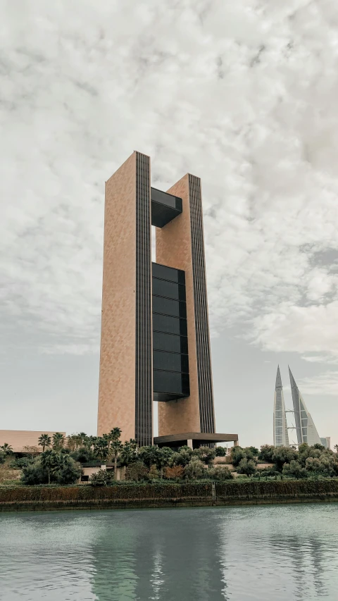 a tall building sitting next to a body of water, by Ahmed Yacoubi, skybridge towers, brutalist appearance, arabia, high res 8k