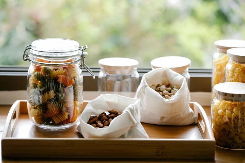 a tray of food sitting on top of a window sill, jars, nut, sustainable materials, hotel room