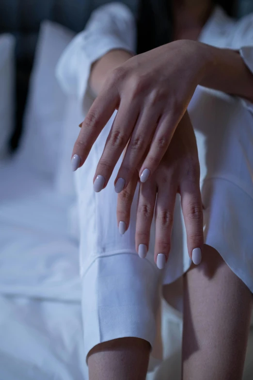 a woman sitting on a bed with her hands on her knees, inspired by Elsa Bleda, unsplash, renaissance, neat nails, soft white rubber, (night), ignant