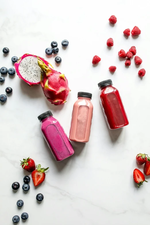 a group of fruit juices sitting on top of a table, magenta and blue, drinking a strawberry iced latte, detailed product image, bottle