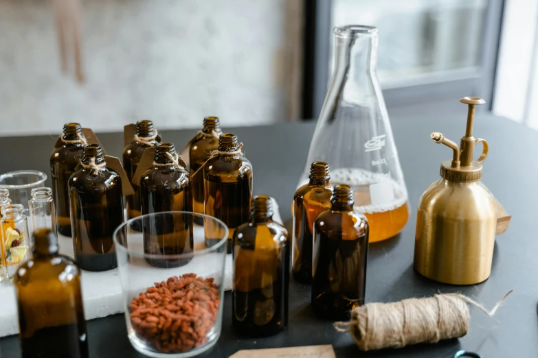 a bunch of bottles sitting on top of a table, unsplash, process art, soap, beakers, brown, recipe