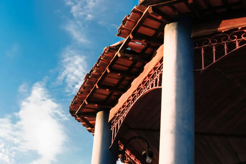 a clock that is on the side of a building, wooden ceiling, colonnade, azure and red tones, nepali architecture buildings