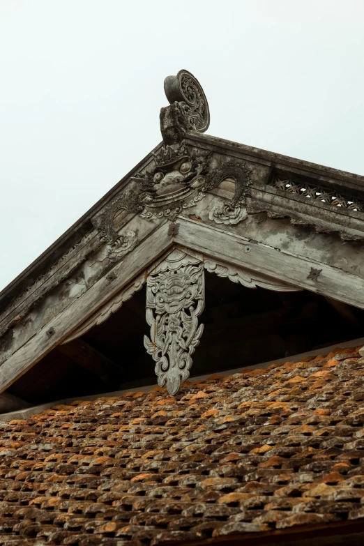 a close up of a roof with a clock on it, inspired by Sesshū Tōyō, romanesque, vietnamese temple scene, damaged structures, intricate details photograph, simple gable roofs