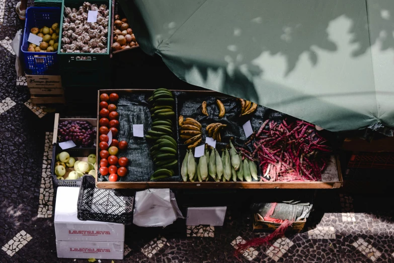 an overhead view of a fruit and vegetable stand, a photo, by Julia Pishtar, unsplash, romanian, on a sunny day, cardboard, beans