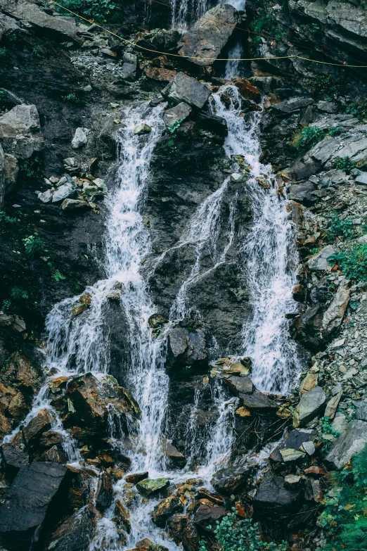 a couple of people standing in front of a waterfall, by Muggur, close-up from above, lush surroundings, unsplash 4k, texture