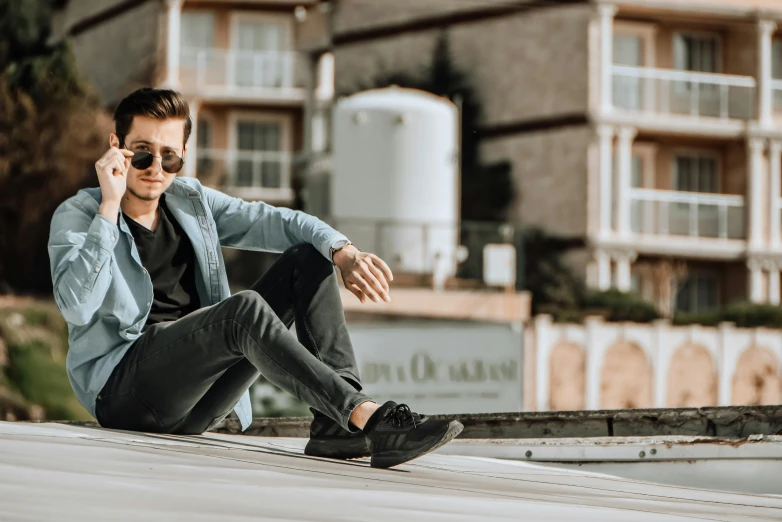a man sitting on the ground talking on a cell phone, by Niko Henrichon, pexels contest winner, realism, doing a sassy pose, standing on a rooftop, with sunglass, avatar image