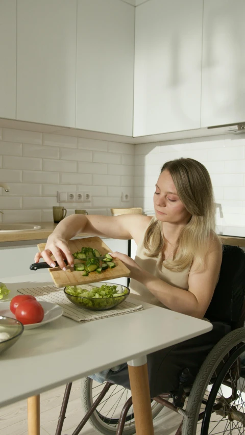 a woman in a wheelchair preparing food in a kitchen, pexels, cutting a salad, avatar image, blonde, cinematic photo