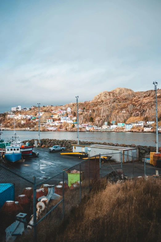 a harbor filled with lots of boats next to a mountain, by Brian Snøddy, quebec, high-quality photo, out worldly colours, hyperrealism photo