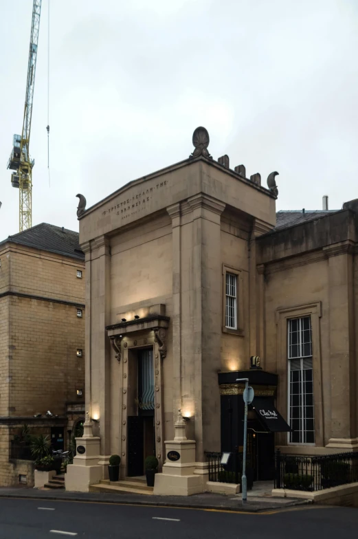 a large building with a crane in the background, neoclassicism, entrance, bath, artsationhq, restaurant in background