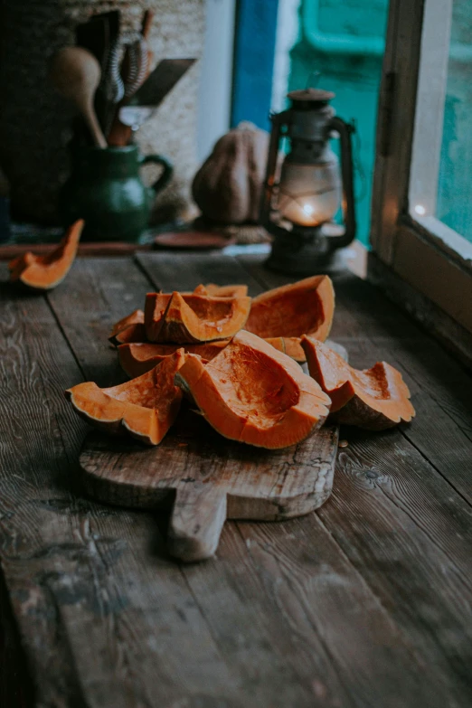 a wooden cutting board sitting on top of a wooden table, gourds, unsplash photo contest winner, cosy atmosphere, promo image