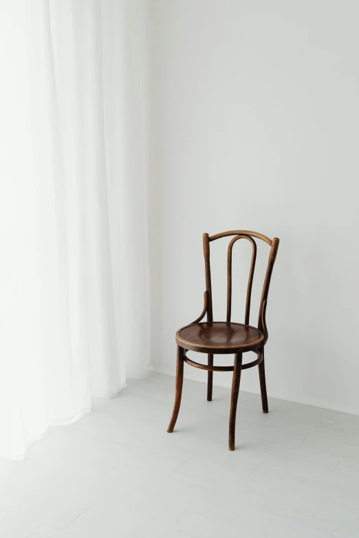 a wooden chair sitting in front of a window, by Matthias Stom, trending on unsplash, in front of white back drop, 2 5 6 x 2 5 6, chocolate, early 2 0 th century