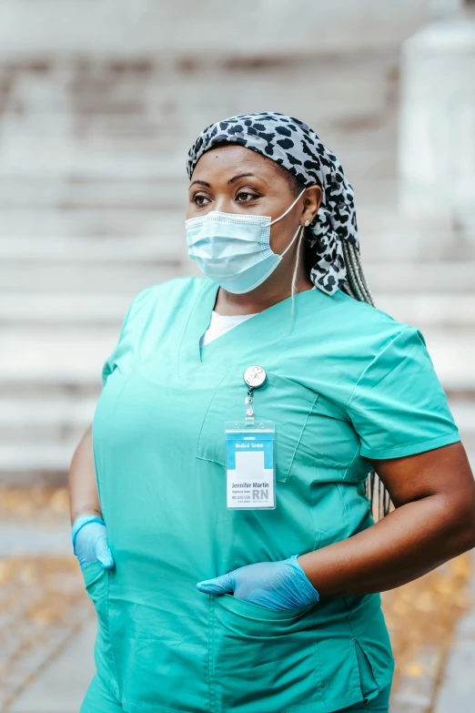 a woman wearing a surgical mask and gloves, by Meredith Dillman, pexels contest winner, teal uniform, african woman, nurse costume, walking confidently