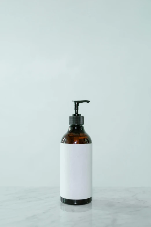 a bottle of liquid sitting on top of a counter, unsplash, private press, clean white paper background, soap, background image, arms to side