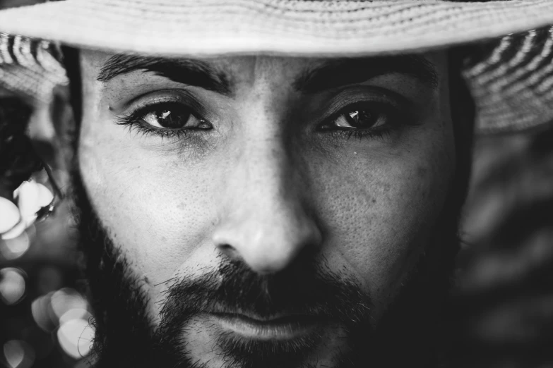 a black and white photo of a man wearing a hat, an album cover, inspired by Germán Londoño, pexels, photorealism, johnny silverhand, navid negahban, eyes, bearded cowboy
