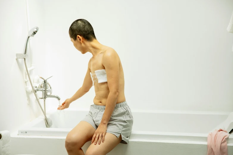 a man sitting on the edge of a bath tub, unsplash, shin hanga, scales covering her chest, intravenous drip, profile image, medical image