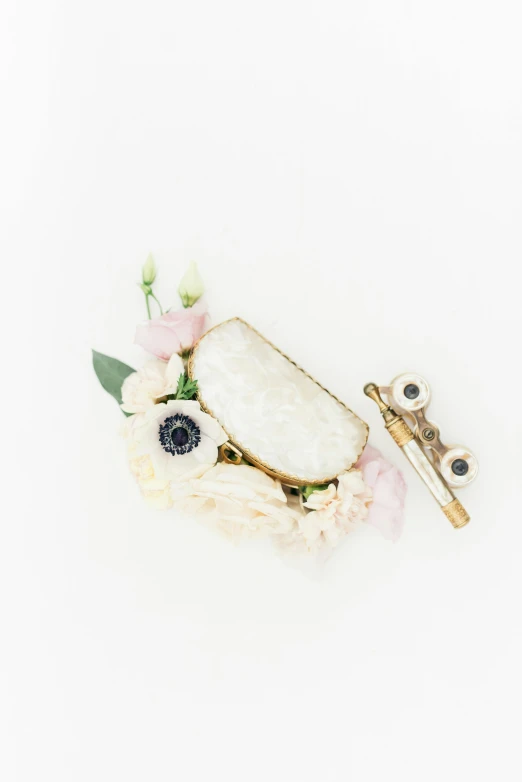 a piece of jewelry sitting on top of a white surface, a picture, by Mona Moore, trending on unsplash, flowers and gold, cream and white color scheme, druzy geode, camera photo