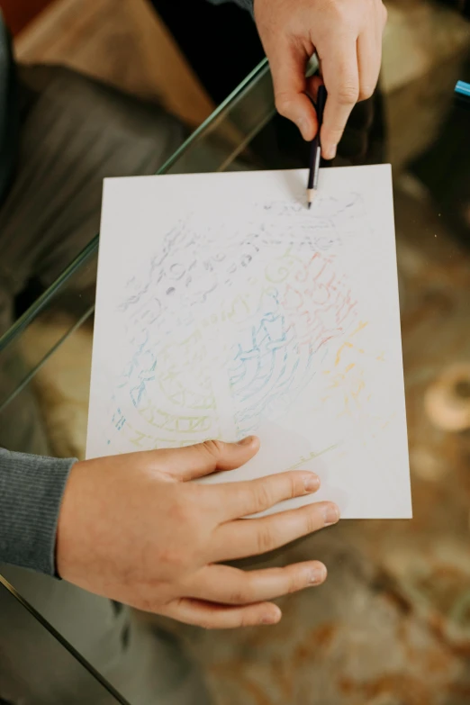 a person holding a piece of paper with a drawing on it, penned with thin colors on white, boys, wedding, prophetic art