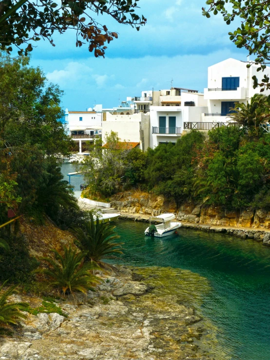 a river running through a lush green forest filled with trees, inspired by January Suchodolski, pexels contest winner, modernism, mediterranean fisher village, with water and boats, apulia, seen from outside