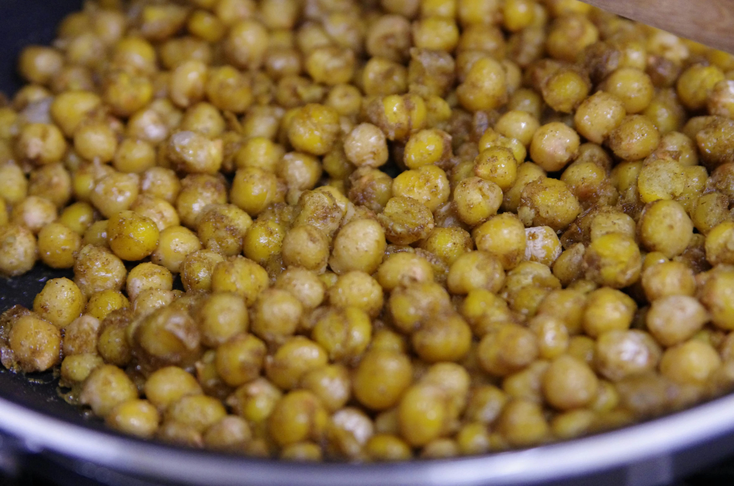 a frying pan filled with cooked chickpeas, by Matt Cavotta, dynamic closeup, some zoomed in shots, mustard, skins