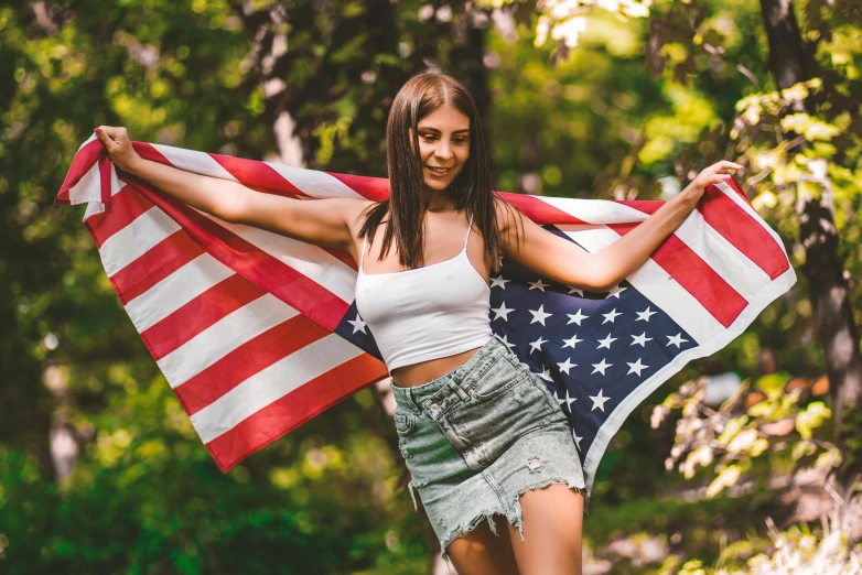 a beautiful young woman holding an american flag, a photo, pexels contest winner, 🚿🗝📝, wearing crop top and miniskirt, avatar image, having a good time