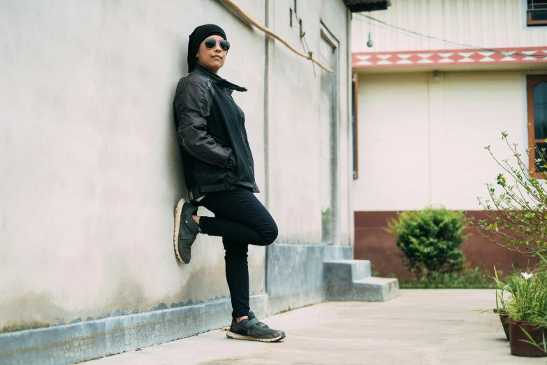 a person leaning against a wall with a skateboard, inspired by Gang Hui-an, an young urban explorer woman, profile image, wearing black boots, wearing a turtleneck and jacket