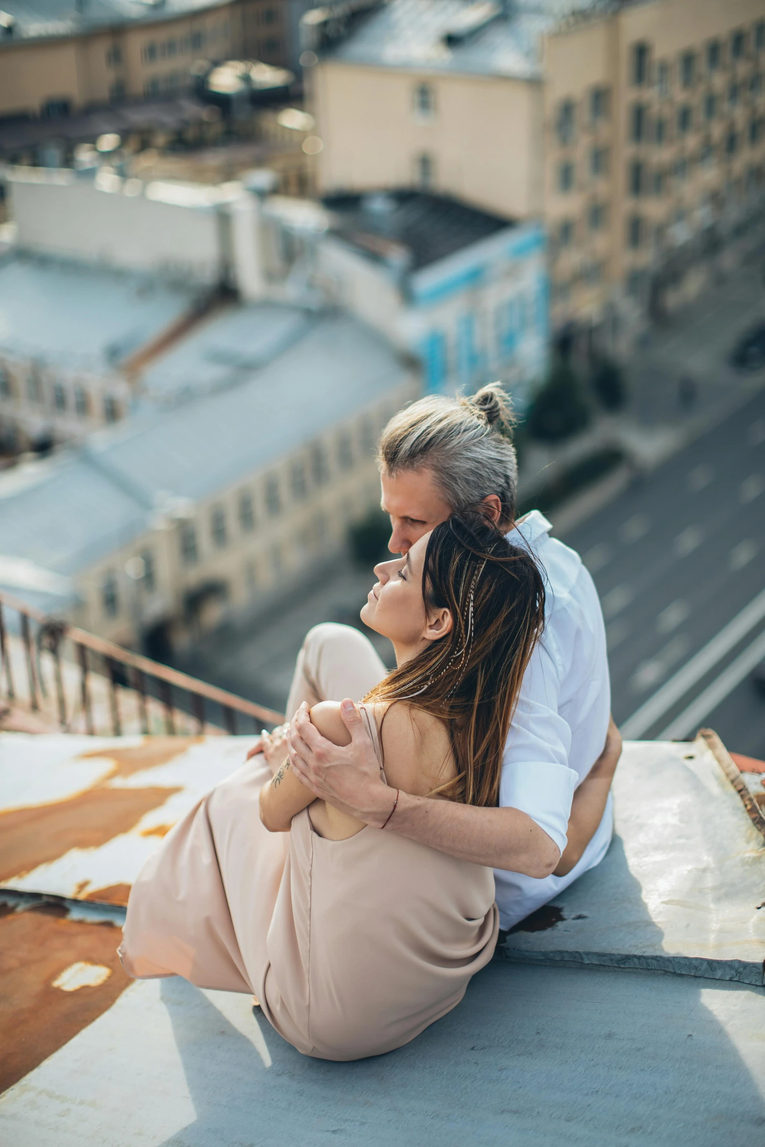 a man and a woman sitting on top of a building, pexels contest winner, romanticism, russian girlfriend, soft texture, cuddling, overlooking