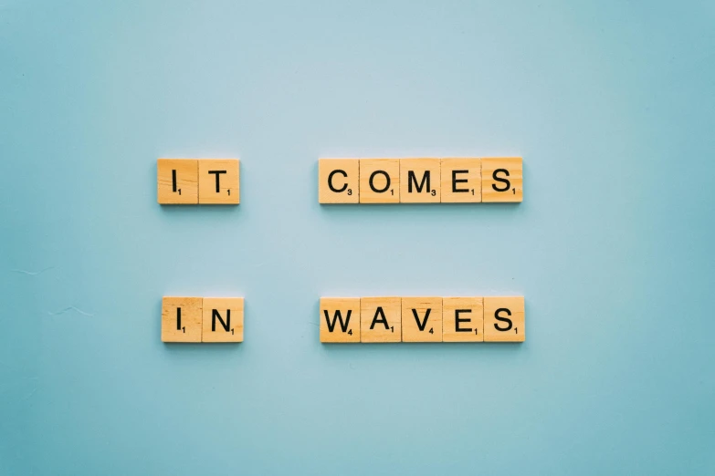 scrabbles spelling it comes in waves on a blue background, by Carey Morris, pexels, acidwave, wood print, sci if, wall art