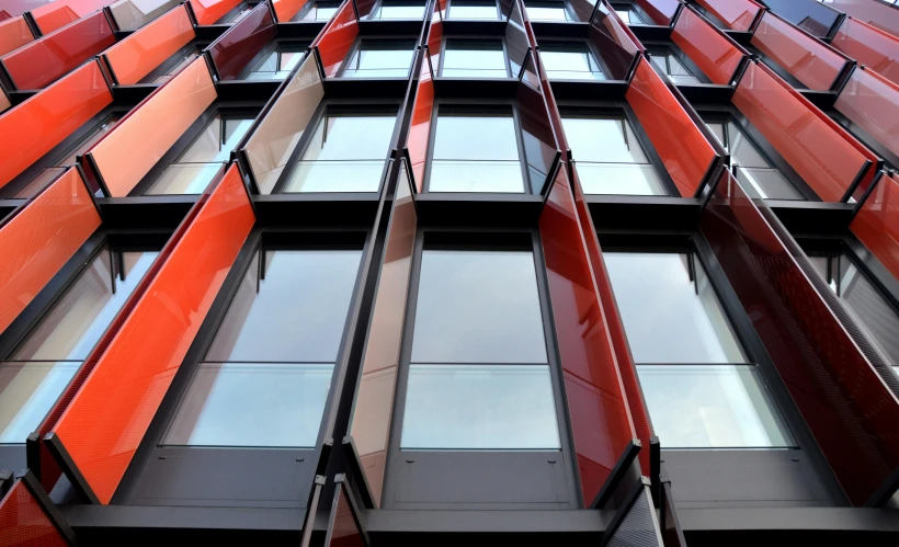 a tall red building with lots of windows, inspired by Richard Wilson, flickr, dark grey and orange colours, sustainable architecture, closeup shot, award winning shopfront design