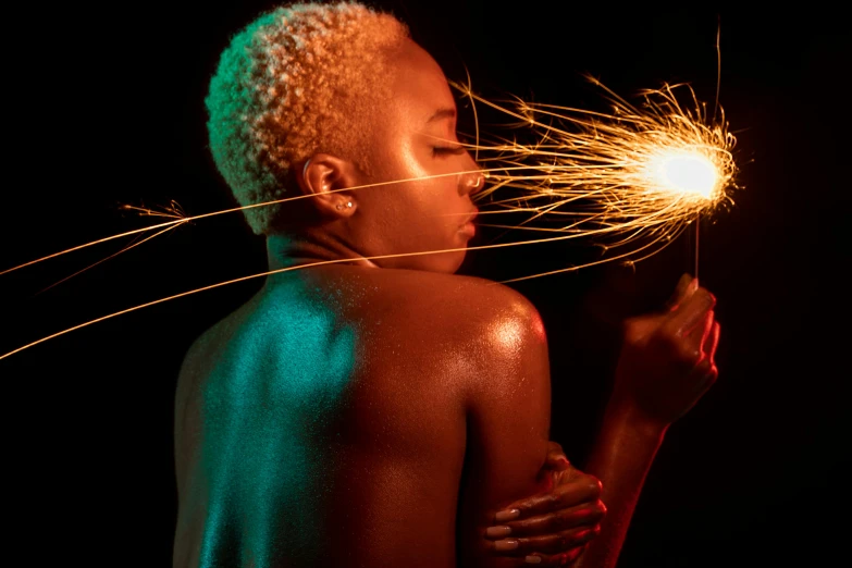 a woman holding a sparkler in her hand, afrofuturism, flames around body, non binary model, ray of light through white hair, man is with black skin