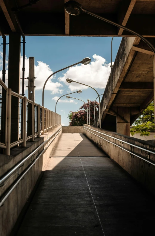 an empty walkway leading to a train station, by William Woodward, puerto rico, sky bridge, afternoon lights, multi - level