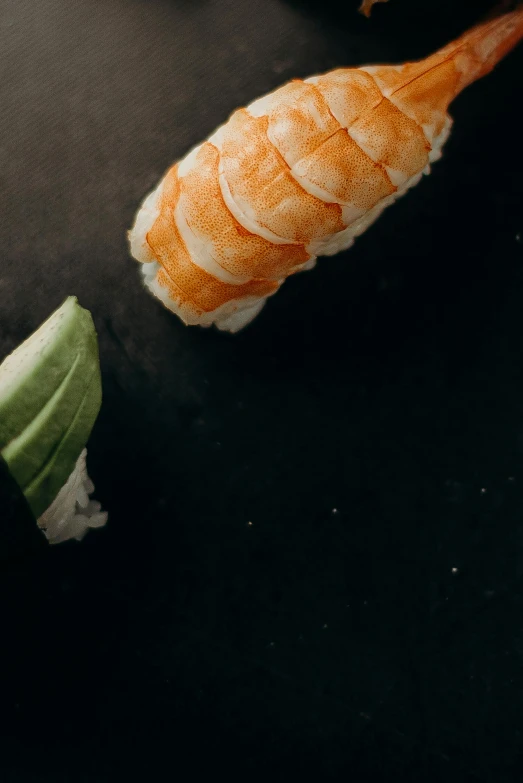 a couple of sushi sitting on top of a black table, twisting leaves, zoomed in, thumbnail, shrimp