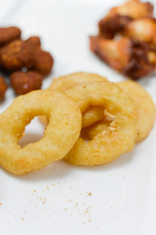 a white plate topped with onion rings and nuts, ivan bolivian, 4 0 mm, various sizes, vitorugo