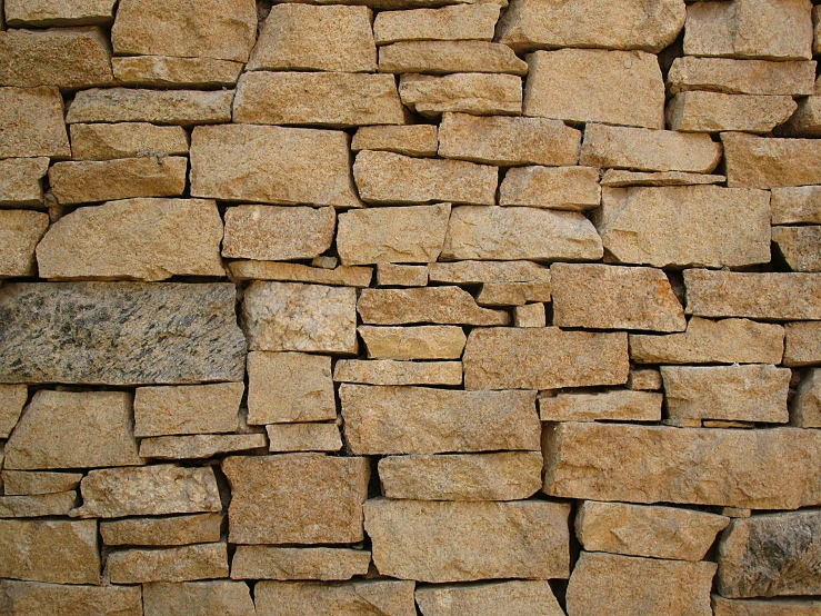 a fire hydrant sitting in front of a stone wall, an album cover, by Jan Rustem, minimalism, ((rocks)), tessellation, light - brown wall, stacked
