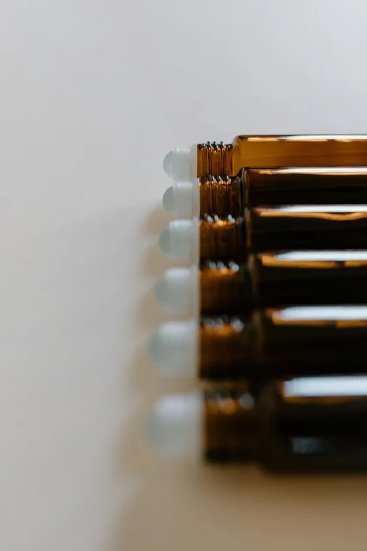 a row of toothbrushes sitting on top of a table, unsplash, visual art, liquid translucent amber, shot from below, detailed product image, stacked