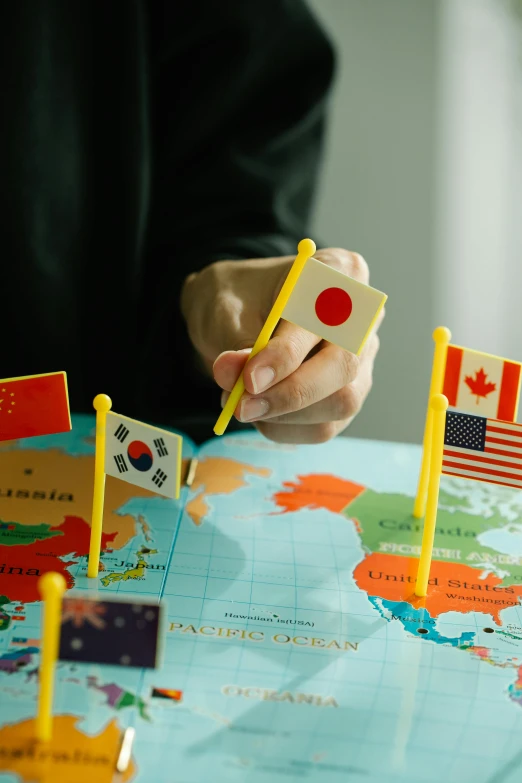 a person sitting at a table with a map and flags, japanese collection product, yellow, slide show, united states