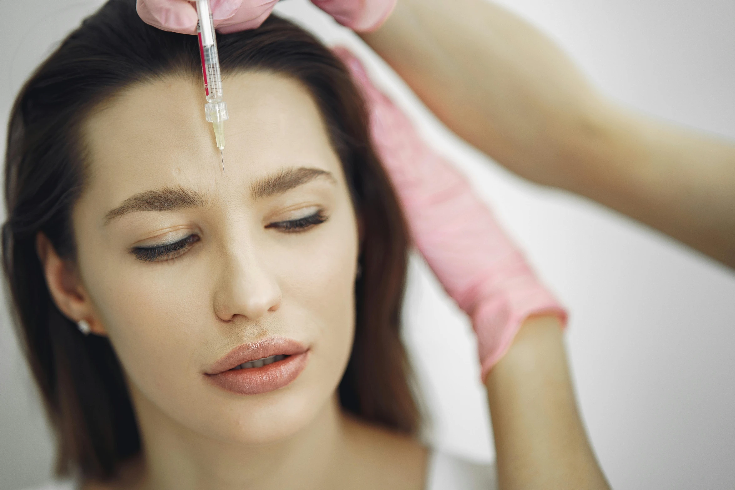 a woman getting an injection from a doctor, by Matija Jama, shutterstock, relaxed eyebrows, head tilted down, thumbnail, brunette