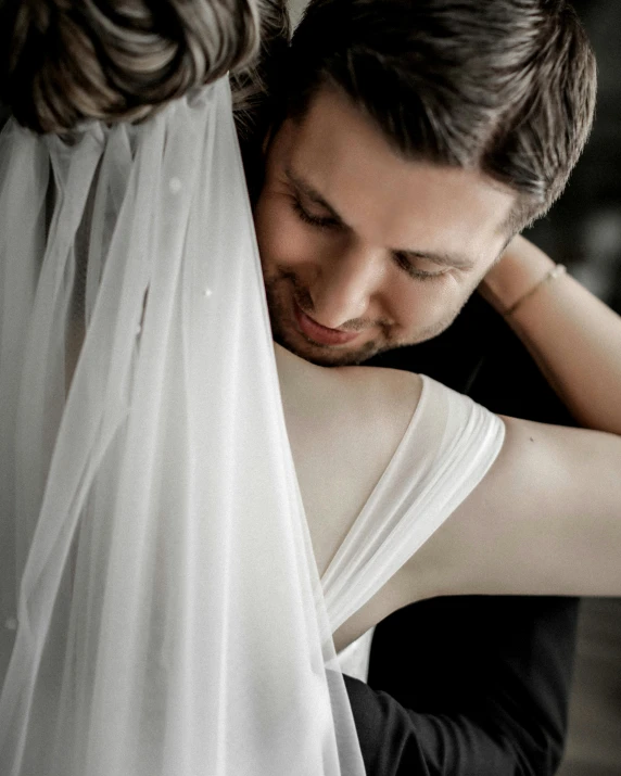 a man and a woman hugging each other, a colorized photo, by Arabella Rankin, trending on unsplash, renaissance, bride, white ribbon, wearing translucent sheet, lgbt