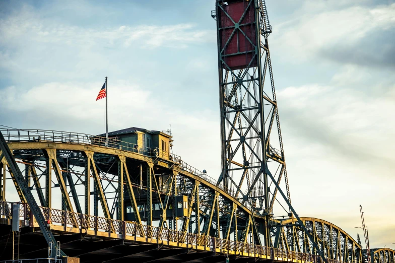 a bridge over a body of water under a cloudy sky, a portrait, by Steve Brodner, unsplash, art nouveau, industrial colours, yellow, portland oregon, 2 5 6 x 2 5 6 pixels