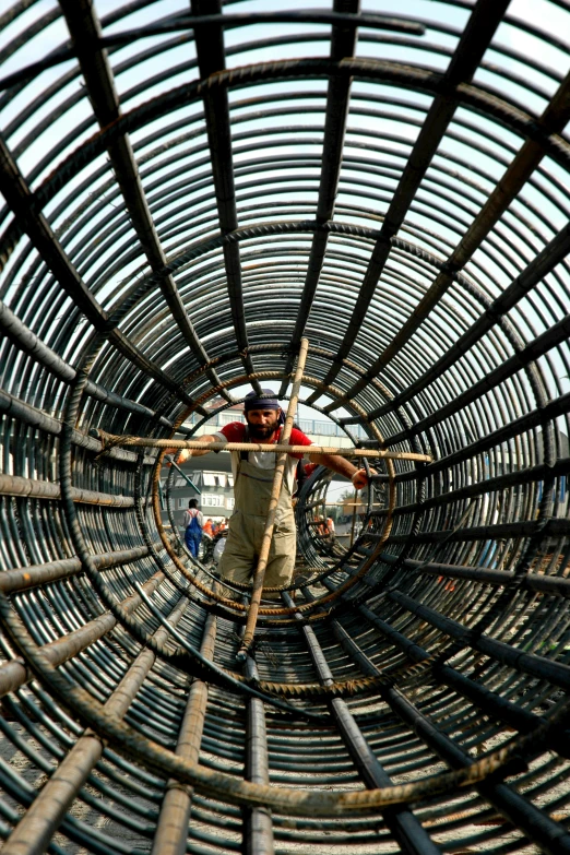 a man standing inside of a metal structure, bangladesh, circle, under construction, reuters