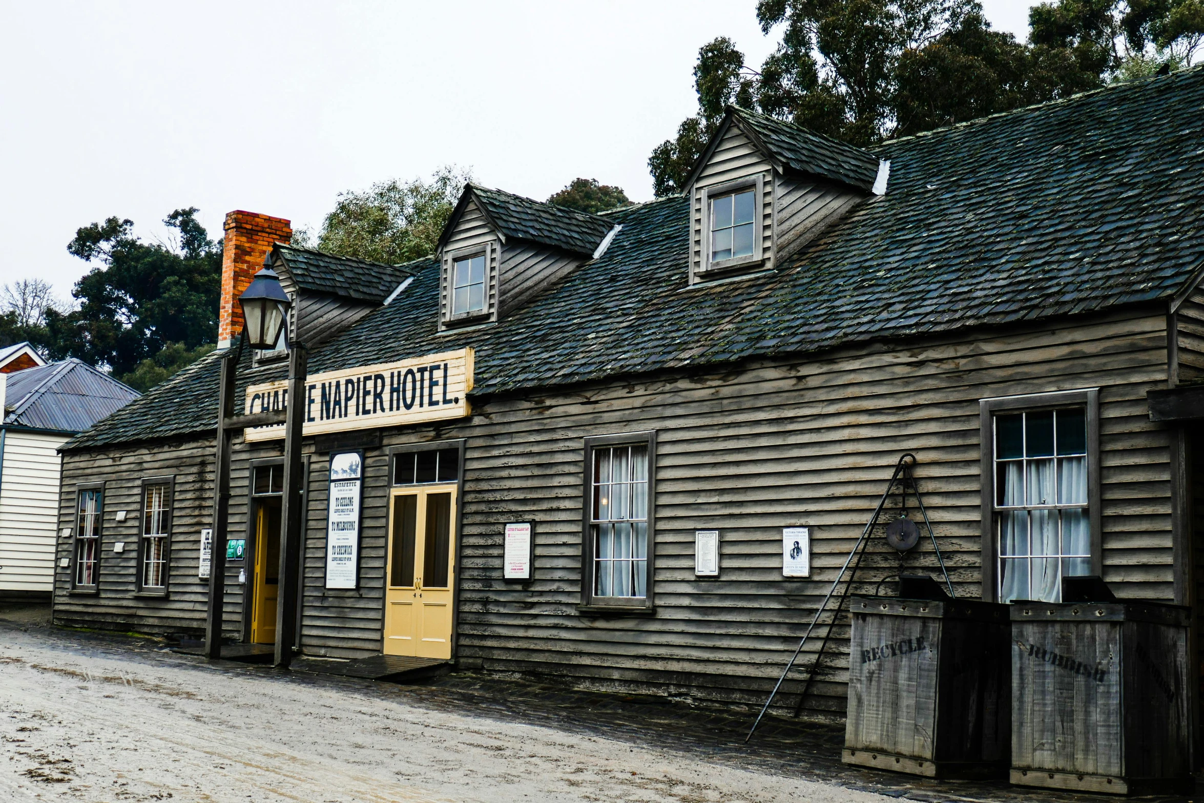 an old wooden building sitting on the side of a road, inspired by George Pirie, happening, historically accurate, vesper lynd, magpie, exterior view