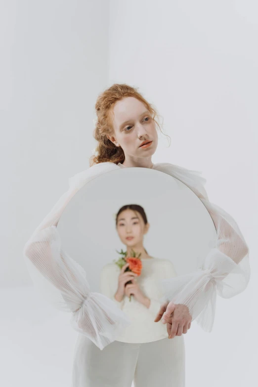 a woman holding a mirror in front of her face, an album cover, inspired by Anna Füssli, renaissance, hr ginger, louise zhang, an all white human, portrait of two people