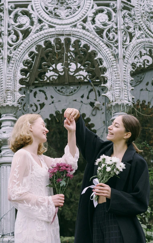 a couple of women standing next to each other, unsplash, neo-romanticism, wedding photo, waving and smiling, very pale skin, romeo and juliet