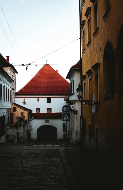 a white building with a red roof in the middle of a street, a picture, unsplash contest winner, baroque, slovakia, bright and moody, colored photo, square