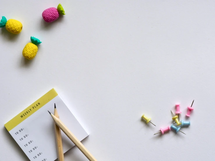 a notepad sitting on top of a desk next to a pencil, pexels contest winner, candy decorations, background image, white minimalistic background, miniatures