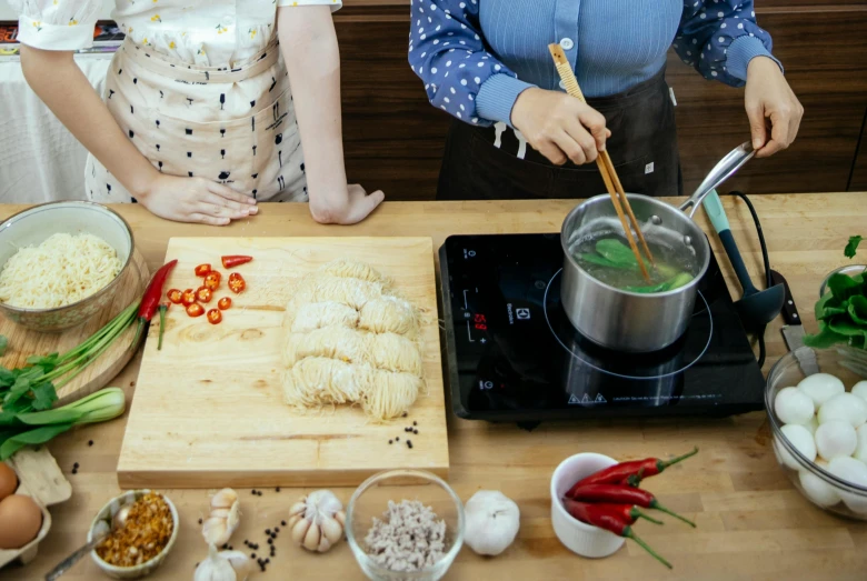 a couple of people that are cooking some food, inspired by Tan Ting-pho, pexels contest winner, square, school class, tabletop, background image