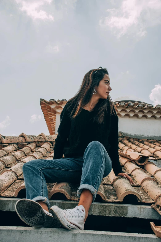 a woman sitting on top of a roof, trending on pexels, renaissance, wearing jeans and a black hoodie, tiled roofs, profile image, peruvian looking