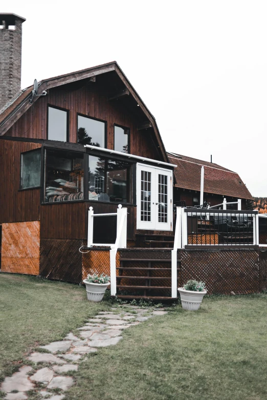 a brown house sitting on top of a lush green field, unsplash, behind bar deck with bear mugs, d. i. y. venue, profile image, exterior view